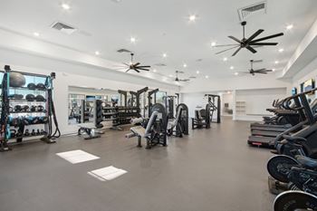 a gym with a lot of weights and exercise equipment  at The Maddox Luxury Apartment Homes, Buckeye, AZ, 85326